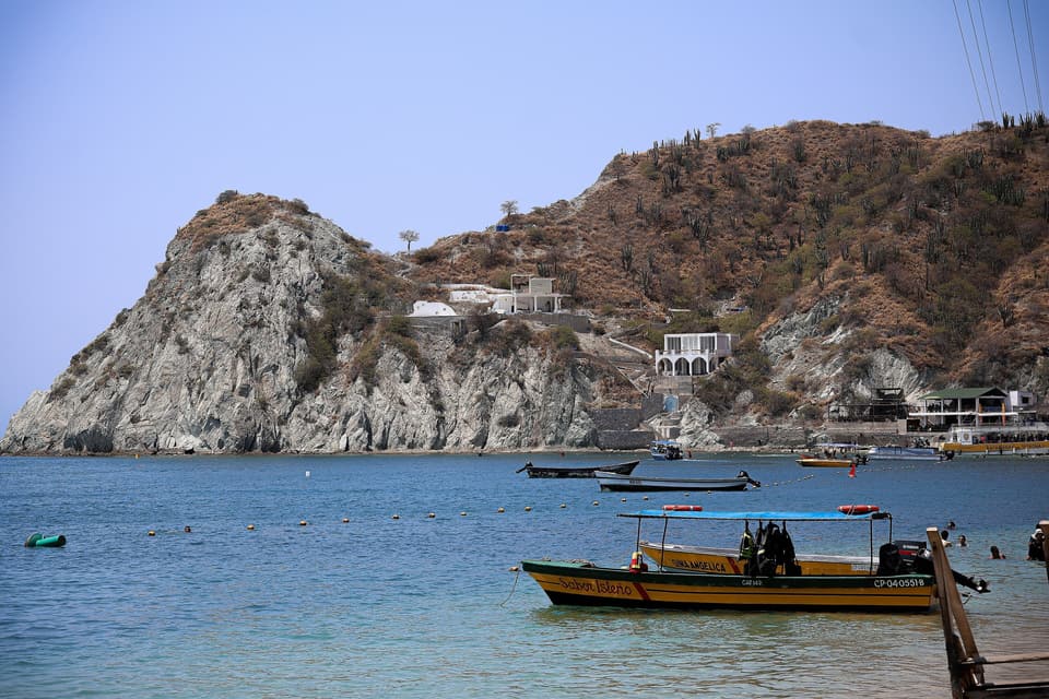 La bahía de Taganga con lanchas de pescadores y cerros secos.